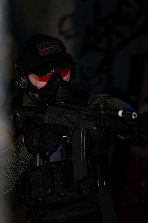 Joueur airsoft en action masque à gaz pendant une partie sur terrain airsoft