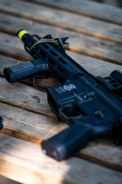 Powergun airsoft compacte type CQB posée sur terrasse en bois – détail réplique