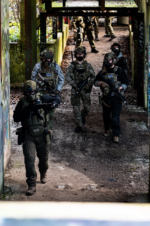 Team airsoft en progression CQB dans un bâtiment industriel désaffecté